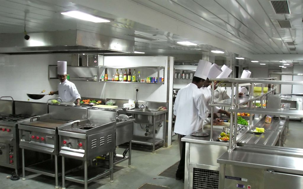 Chefs working with food processors in a fast food restaurant kitchen