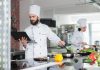 The Ultimate Guide To Open A Cloud Kitchen In India In 2023 Cloud Kitchen Chef cooking and holding a tablet