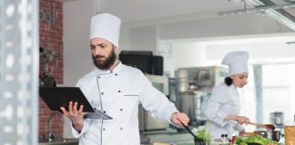 Cloud Kitchen Chef cooking and holding a tablet