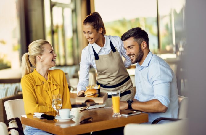 Restaurant staff serving customers on table