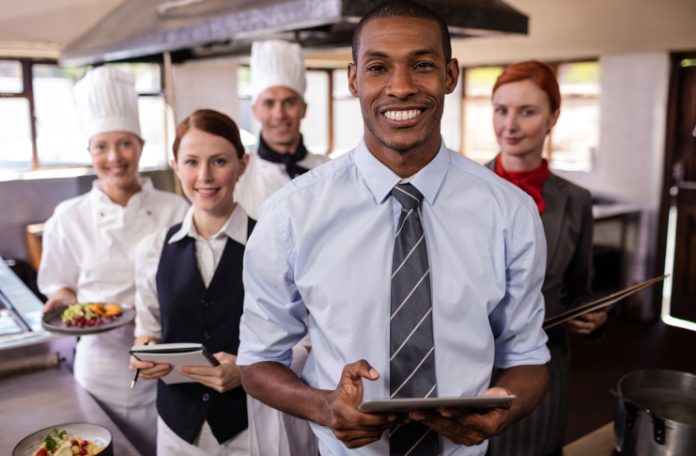 Entire restaurant staff smiling for a kitchen snapshot