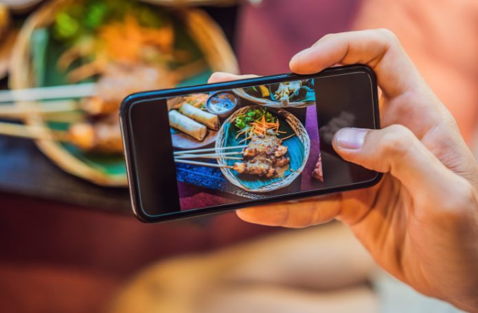 Restaurant customer taking a picture of food with mobile phone