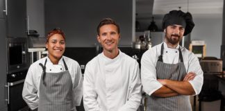 The Ultimate 2023 Guide To Restaurant Staff Management – All You Need To Know Three kitchen staff members posing for a photograph in a restaurant's Kitchen
