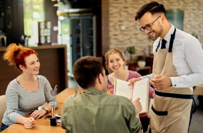 Restaurant staff taking order from customers on the table