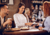Restaurant Loyalty Programs: A Comprehensive Guide Woman using smartphone to pay bill in a restaurant