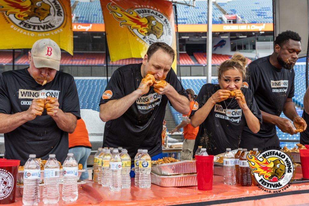People participating in an eating competition at the Buffalo Wing Festival 
