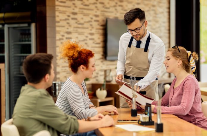 Restaurant staff attending customers at a table