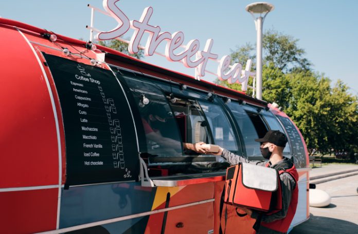 Food Delivery Executive picking up Order from a Food Truck