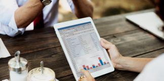 7 Restaurant Reports That Give You Crucial Insights About Your Restaurant Business In 2023 Person looking at restaurant reporting dashboard on a tablet