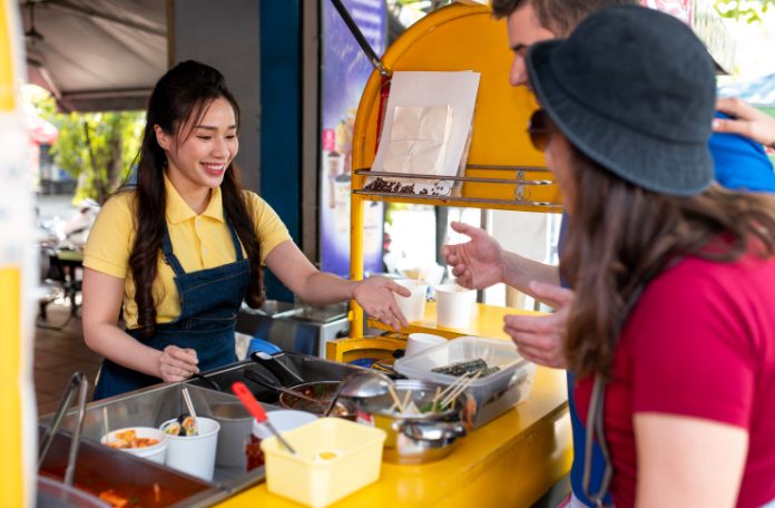 Woman serving customers at a food cart
