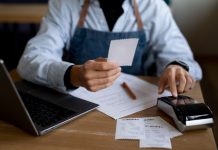 Top Restaurant POS Features To Look For In 2024 Restaurant Staff holding a bill receipt