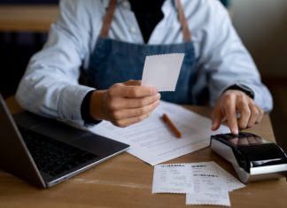 Top Restaurant POS Features To Look For In 2024 Restaurant Staff holding a bill receipt