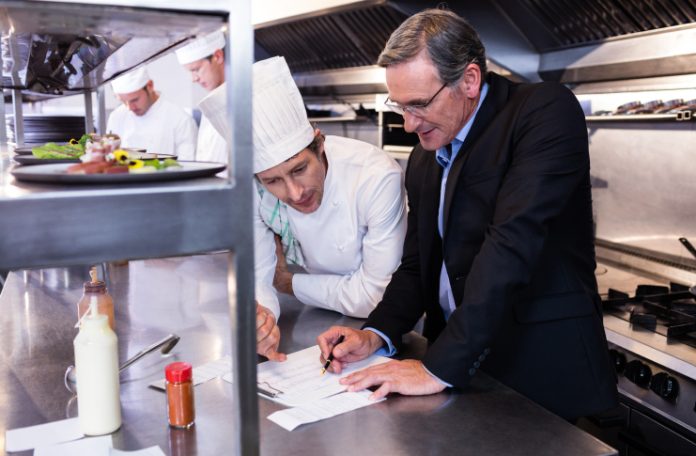 Restaurant manager and chef calculating the food costs