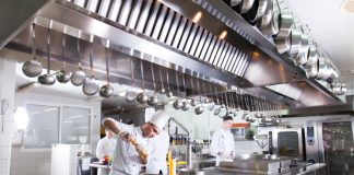 A chef working in a well equipped fast food restaurant kitchen