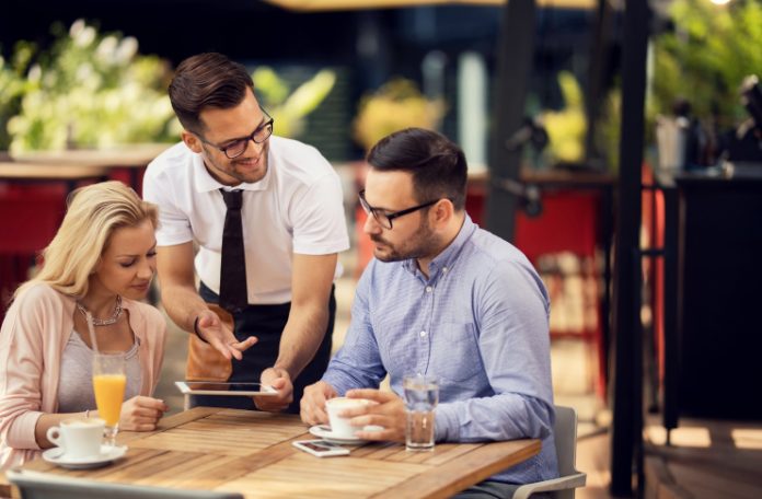 Restaurant staff attending the customers at their table