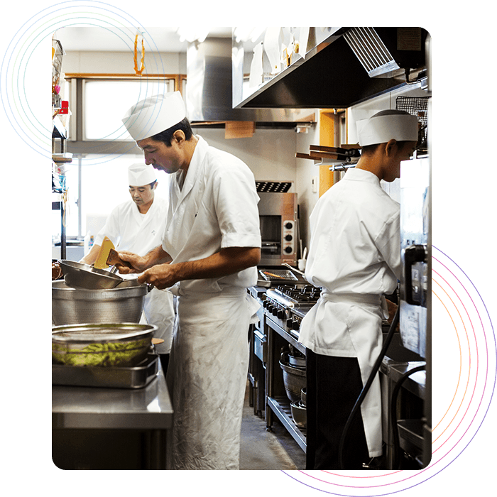 Kitchen Management Three chefs preparing orders in a restaurant kitchen