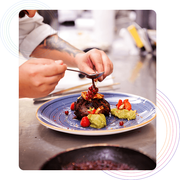 A chef carefully garnishing food in a restaurant